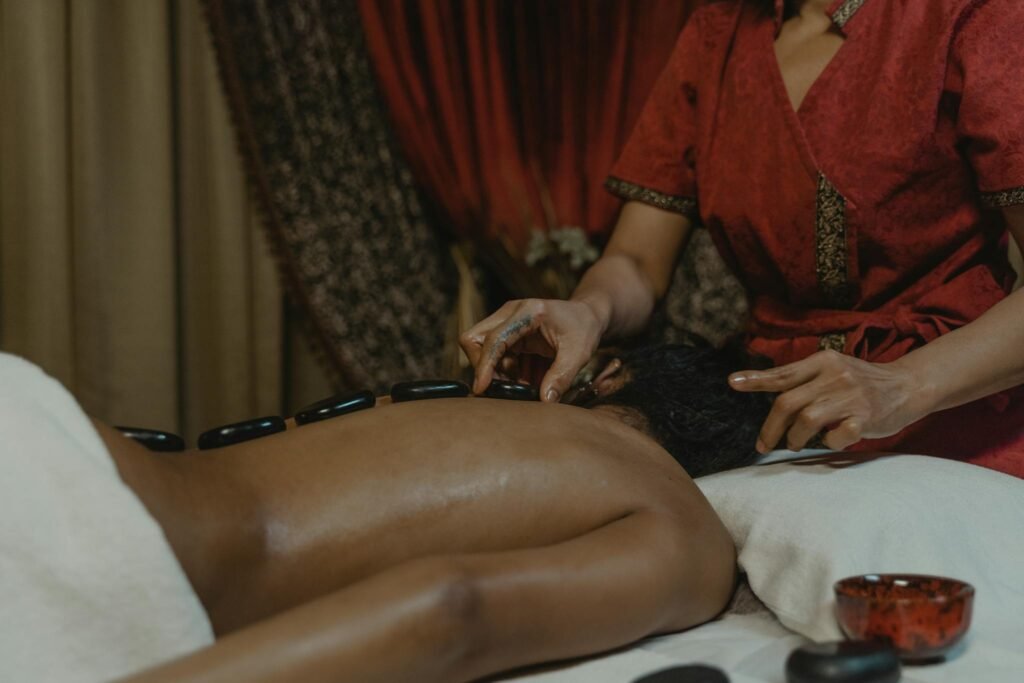 Person receiving a relaxing hot stone massage in a serene spa setting for ultimate relaxation.
